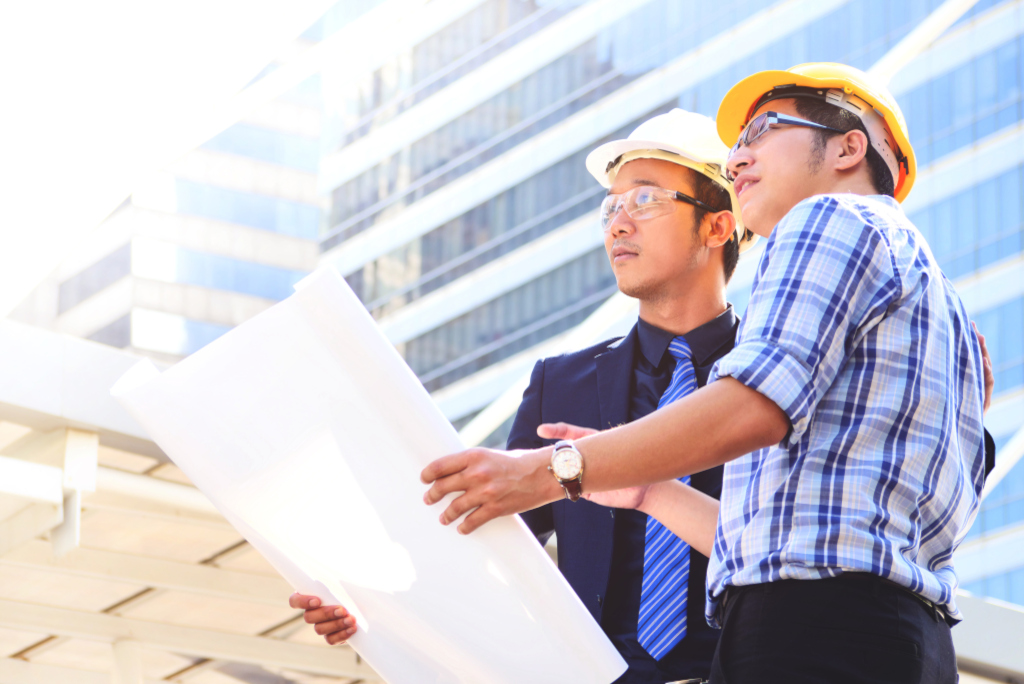 Two businessman looking away for new project while working at constructions site. Copy space.