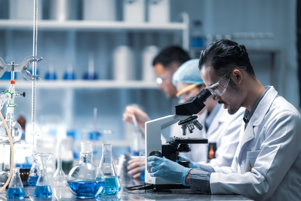 Young scientist looking through a microscope in a laboratory. Young scientist doing some research.